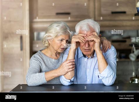 Senior Woman Comforting Her Husband At Home Stock Photo Alamy