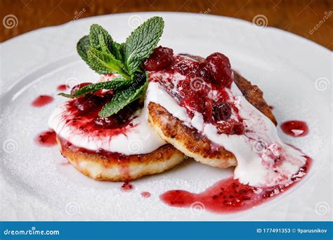 Cheese Pancake Cheesecakes With Sour Cream Jam And Mint On A Plate