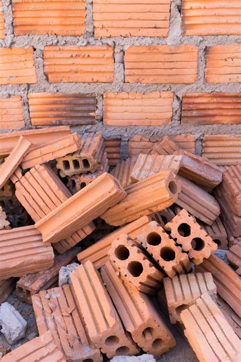 Pila De Ladrillos En Emplazamiento De La Obra Con La Pared De Ladrillo