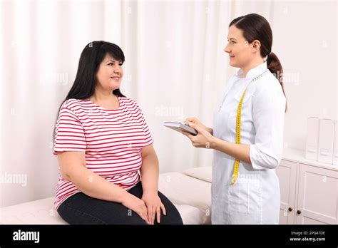 Overweight Mature Woman Consulting With Nutritionist In Clinic Stock
