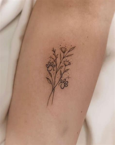 A Small Flower Tattoo On The Left Side Of The Right Arm With Tiny