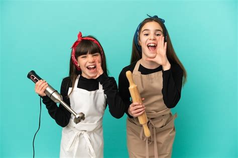 Hermanitas Cocinando En Casa Aislado Sobre Fondo Azul Gritando Y