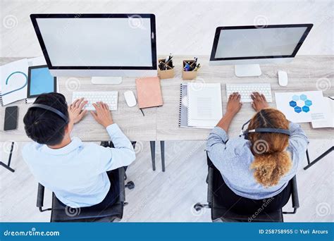 Overhead View Of Two Unknown Business People Working On Computers On A