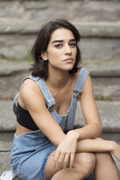 A Woman Sitting On The Ground With Her Legs Crossed And Looking Off To