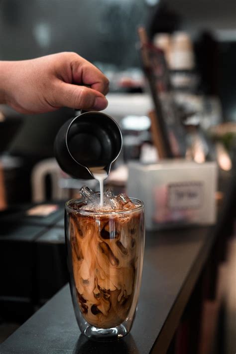 Barista Pouring Milk Into A Glass Of Iced Coffee 2187080 Stock Photo At