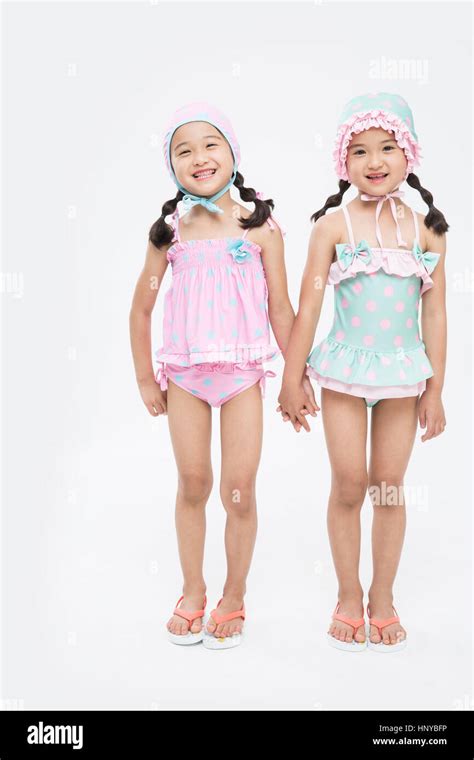 Smiling twin girls in swimsuits Stock Photo - Alamy