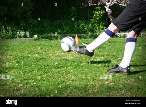 Football being kicked by youth player Stock Photo - Alamy