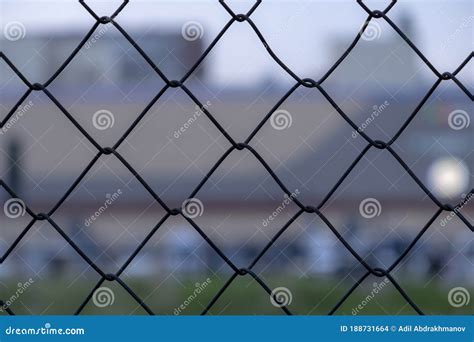 Metall Wire Fence With Unfocused City And Sunset Backgorund Stock Photo