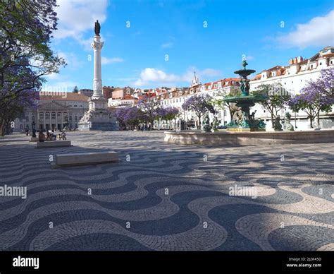 Beautiful Rossio Square In Lisbon In Summer With Purple Trees Stock