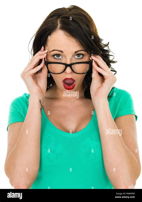 Shocked Young Woman Looking Over Her Glasses With Her Mouth Open In Amazement Isolated Against A