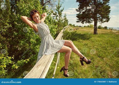 Summer Relax Rustic Portrait Of A Young Woman Sitting On Fence In