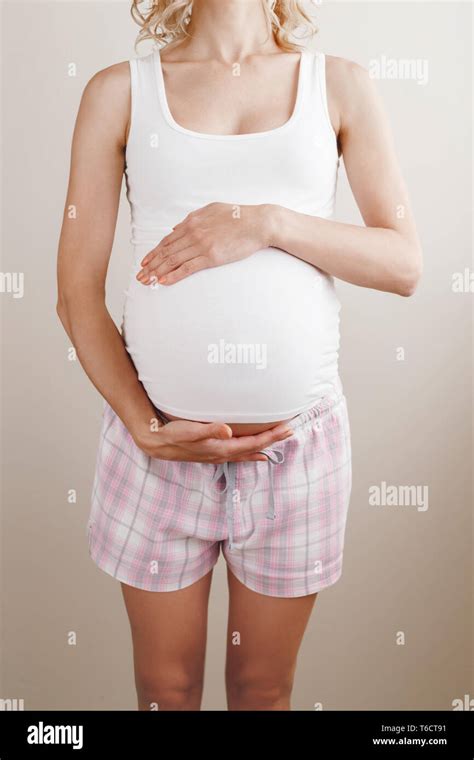 Closeup Body Of White Caucasian Blonde Pregnant Woman In Home Clothes