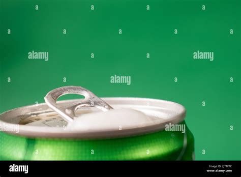 An Artistic Closeup Shot Of An Opened Cold Beer Can On A Green