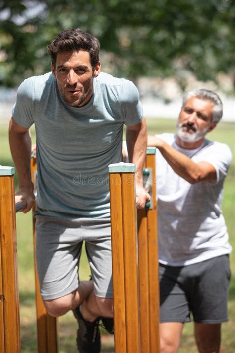 Entrenamiento De Hombres En Chinup Bar Junto Con Entrenador De Ancianos