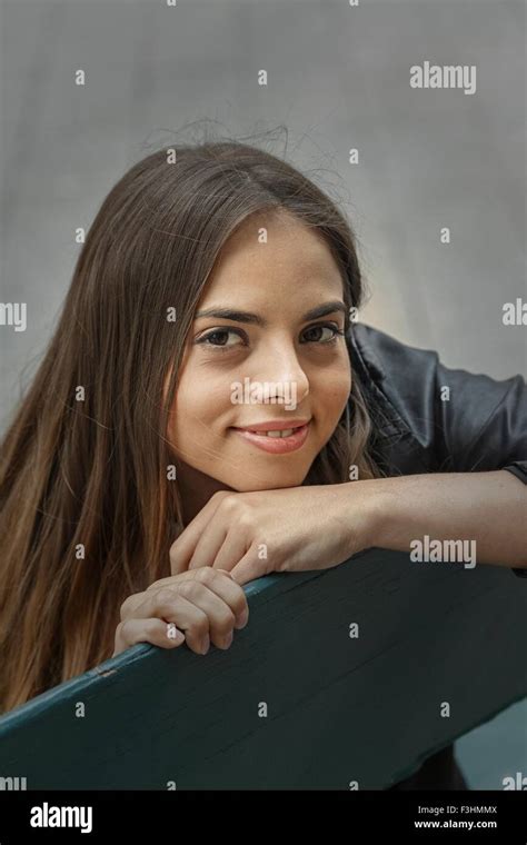 High angle portrait of young woman chin on hand looking at camera ...