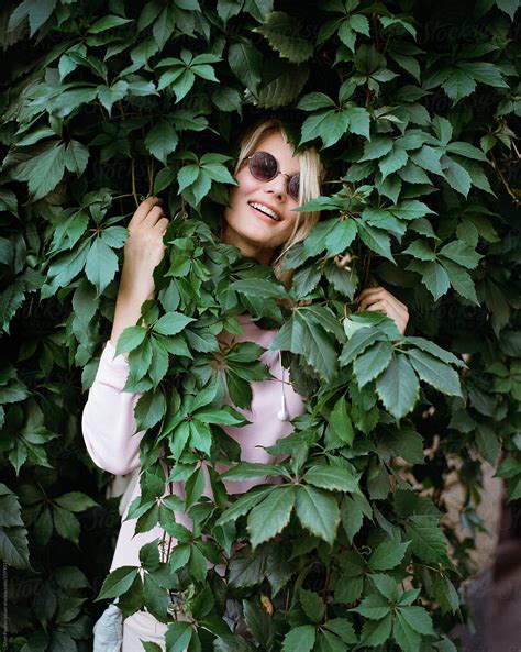 Charming Girl Posing In Green Bush By Stocksy Contributor Duet