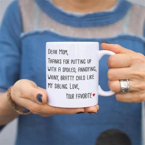 A Woman Holding A Coffee Mug With Writing On It