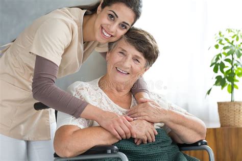 Pretty Caregiver Hugging Disabled Senior Stock Image Image Of Smile