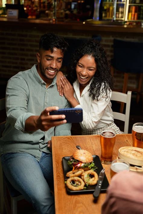 Young Multiracial Couple In Casual Clothing Smiling While Taking Selfie