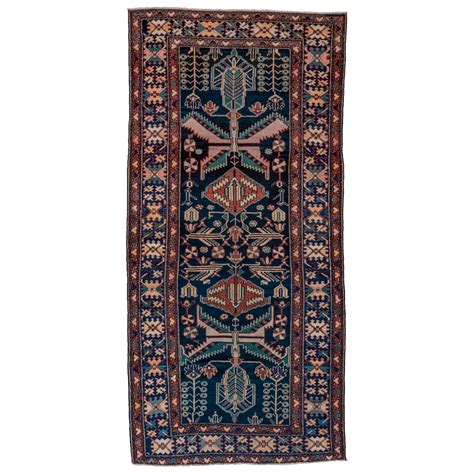 Antique Persian Malayer Rug With A Large Floral Medallion At Center