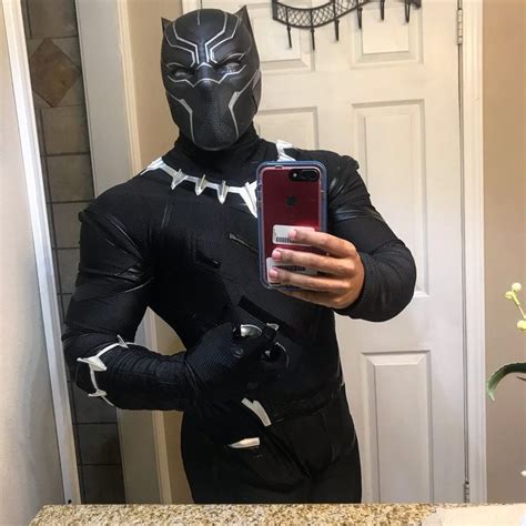 a man in a black and white costume taking a selfie with his cell phone