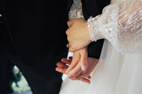 Premium Photo | Young elegant married couple holding hands in wedding day