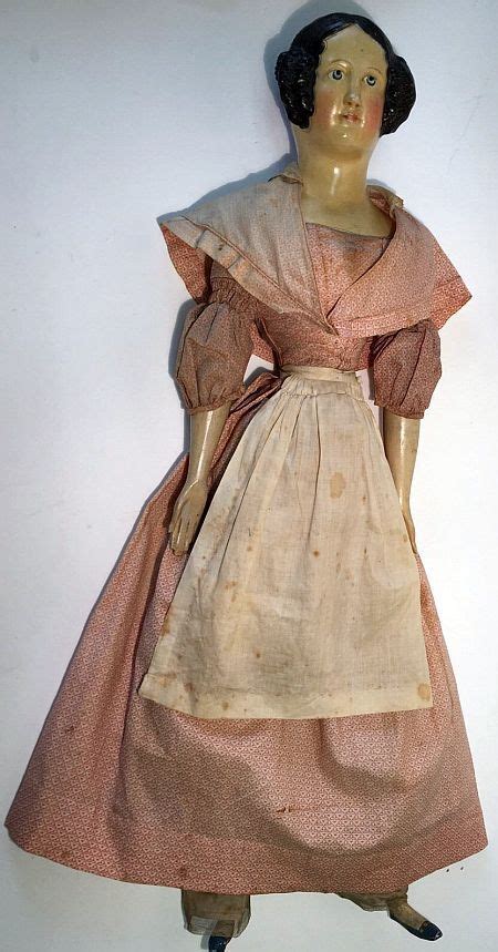 An Old Fashion Doll Is On Display Against A White Background