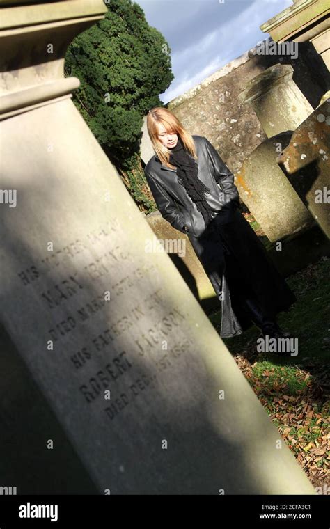 Attractive Blonde Woman In Long Leather Coat Wanders Around Old