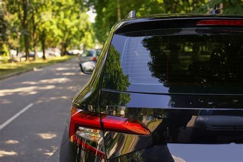 Premium Photo Back Window Of Black Car Parked On The Street In Summer