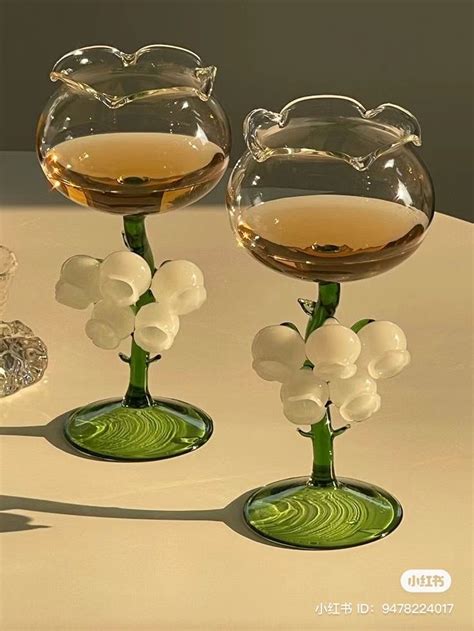 Two Vases With Flowers In Them Sitting On A White Table Top Next To