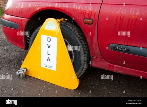 Dvla Wheel Clamp On A Untaxed Car Parked On A Street In England Stock