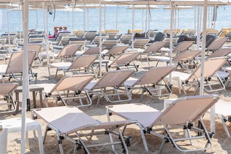 Premium Photo Sunbeds And Parasols On Morning By The Sea Water Beach