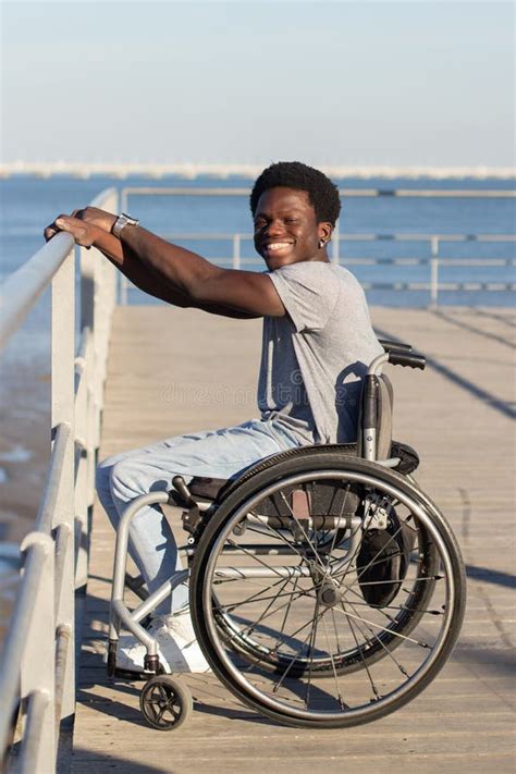 Cheerful Black Man In Wheelchair Spending Time At Seafront Stock Image