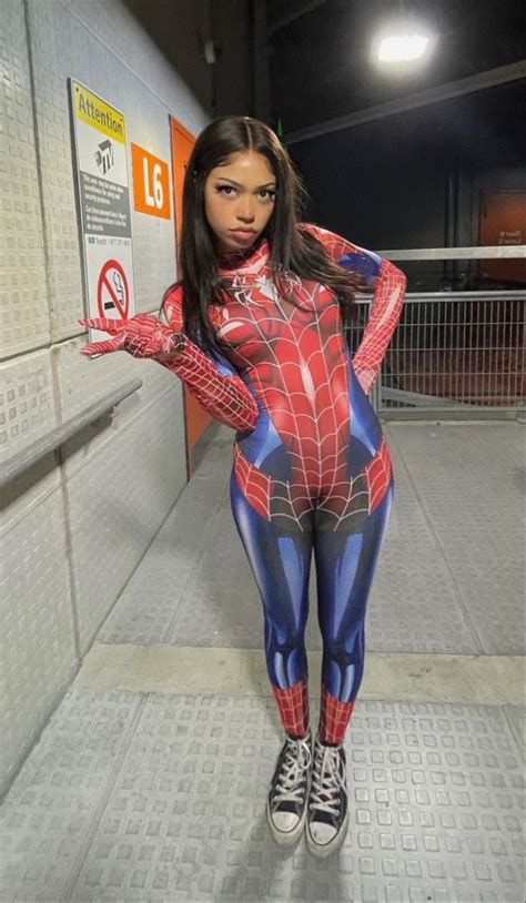 A Woman In A Spider Suit Posing For The Camera With Her Hands On Her Hips