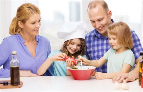 Familia Feliz Con Dos Ni Os Que Hacen La Cena En Casa Foto De Archivo