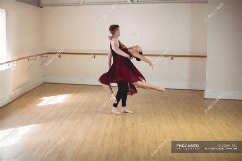 Male And Female Ballet Partners Dancing Together In Modern Studio