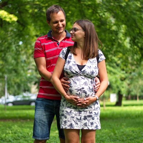 Premium Photo Pregnant Couple Touching Womans Belly Standing In Park