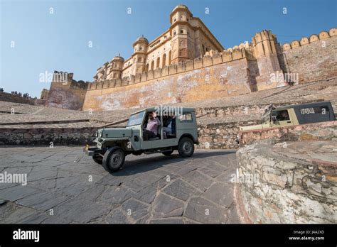 Man Driving A Jeep Passed The Amer Fort In Jaipur India Stock Photo