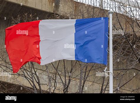 Republic Of France Tricolor Flag In Front Of Concrete Building Stock