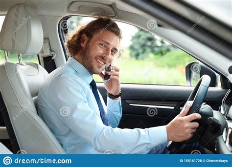 Homem Novo Atrativo Que Fala No Carro Do Quando Do Telefone Foto De