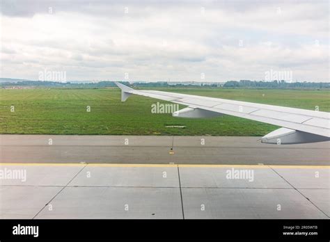 View of airplane wing, blue skies and green land during landing. Airplane window view. Earth and ...