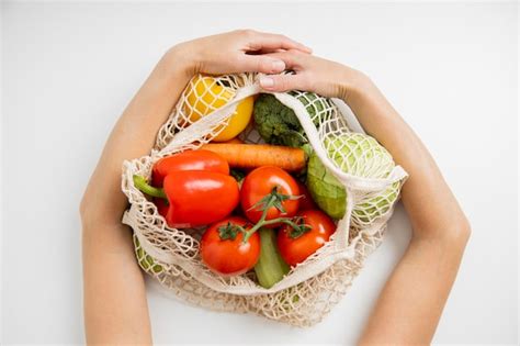 Premium Photo Women S Hands Hold A Bag With Fresh Vegetables On A