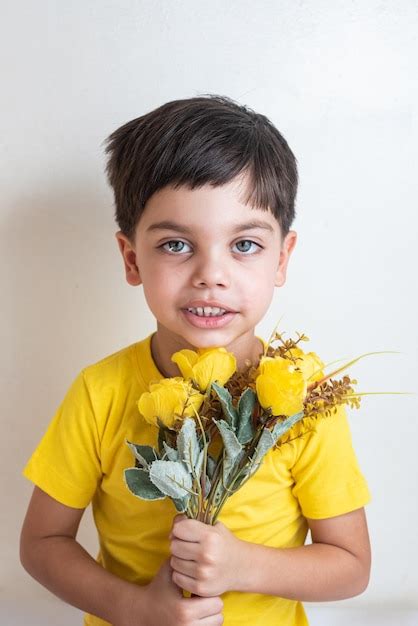 Chico Lindo Y Feliz Con Camiseta Amarilla Con Ramo De Flores Foto Gratis