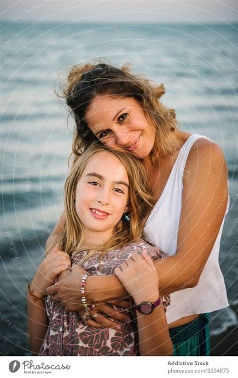 Beautiful Mother And Daughter Embracing On Beach A Royalty Free Stock