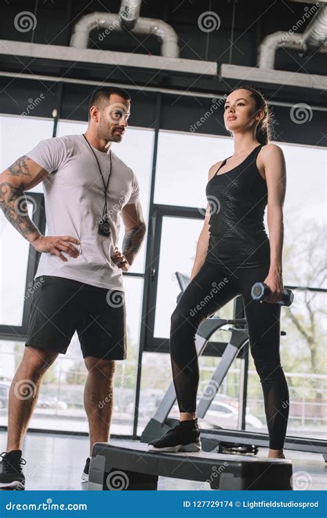 Low Angle View Of Male Personal Trainer And Young Sportswoman Stock