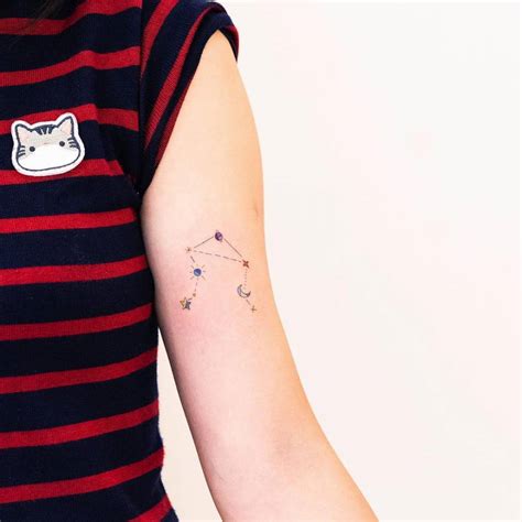 Fine line Libra Constellation tattoo on the bicep.