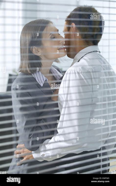 Businesswoman about to kiss businessman in office Stock Photo - Alamy