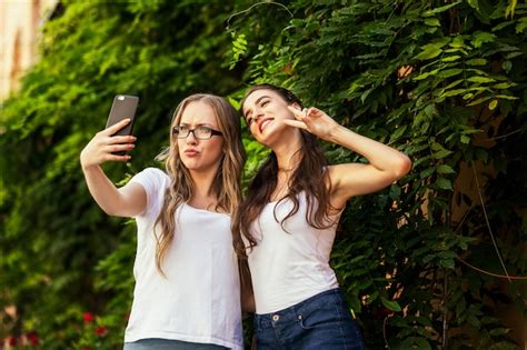 Deux Jeunes Filles Drôles Prennent Des Photos De Selfie Sur Le