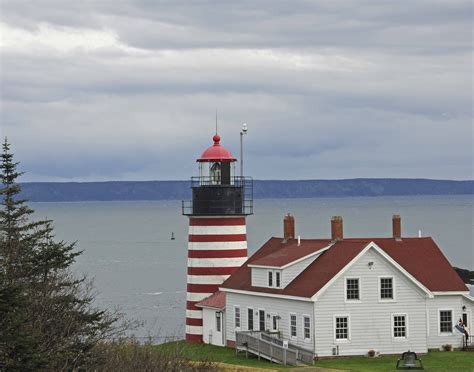 Red White And Blue Lighthouse At Night By Water S Edge