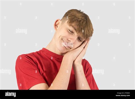 A Studio Portrait Of A Fifteen Year Old Teenage Boy Pretending To Sleep